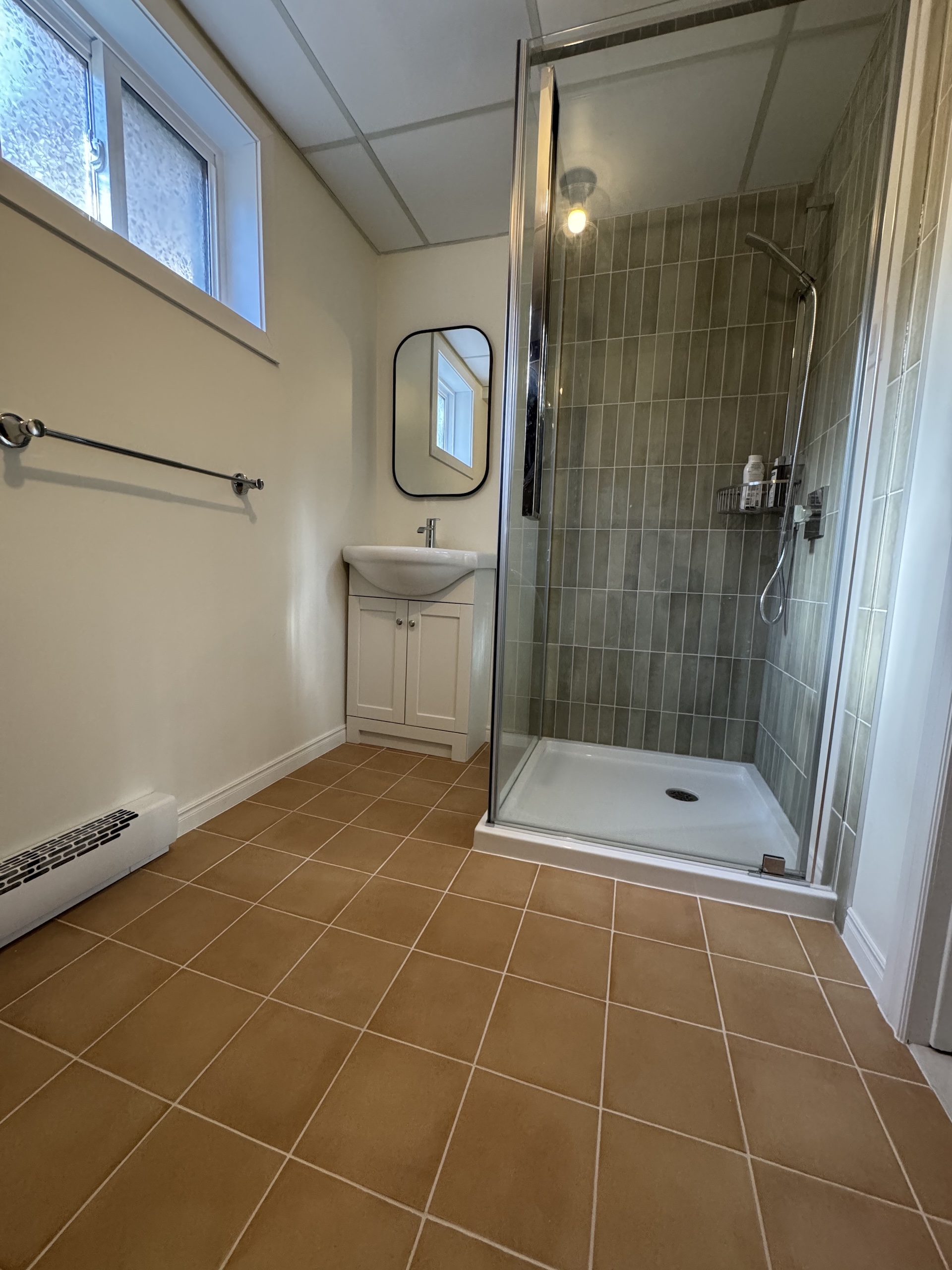 Small guest bathroom renovation with tan floor tiles and white vanity