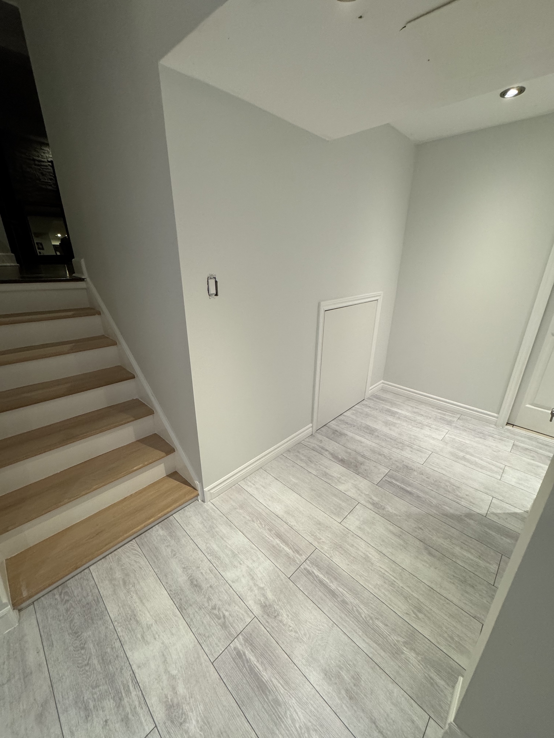Durable grey wood-look porcelain tile installed at staircase landing