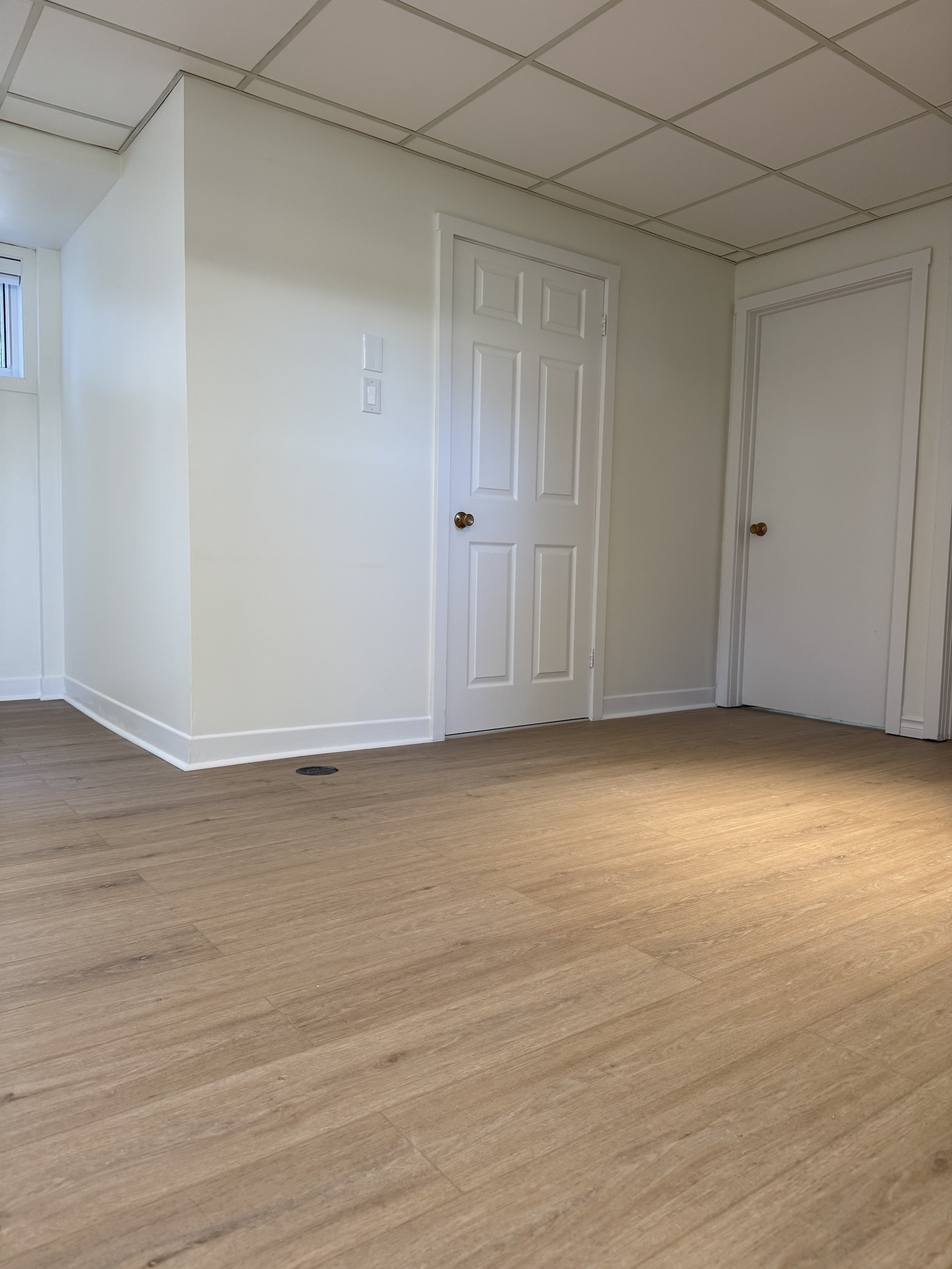 Clean and bright light oak style vinyl flooring installed in a residential room