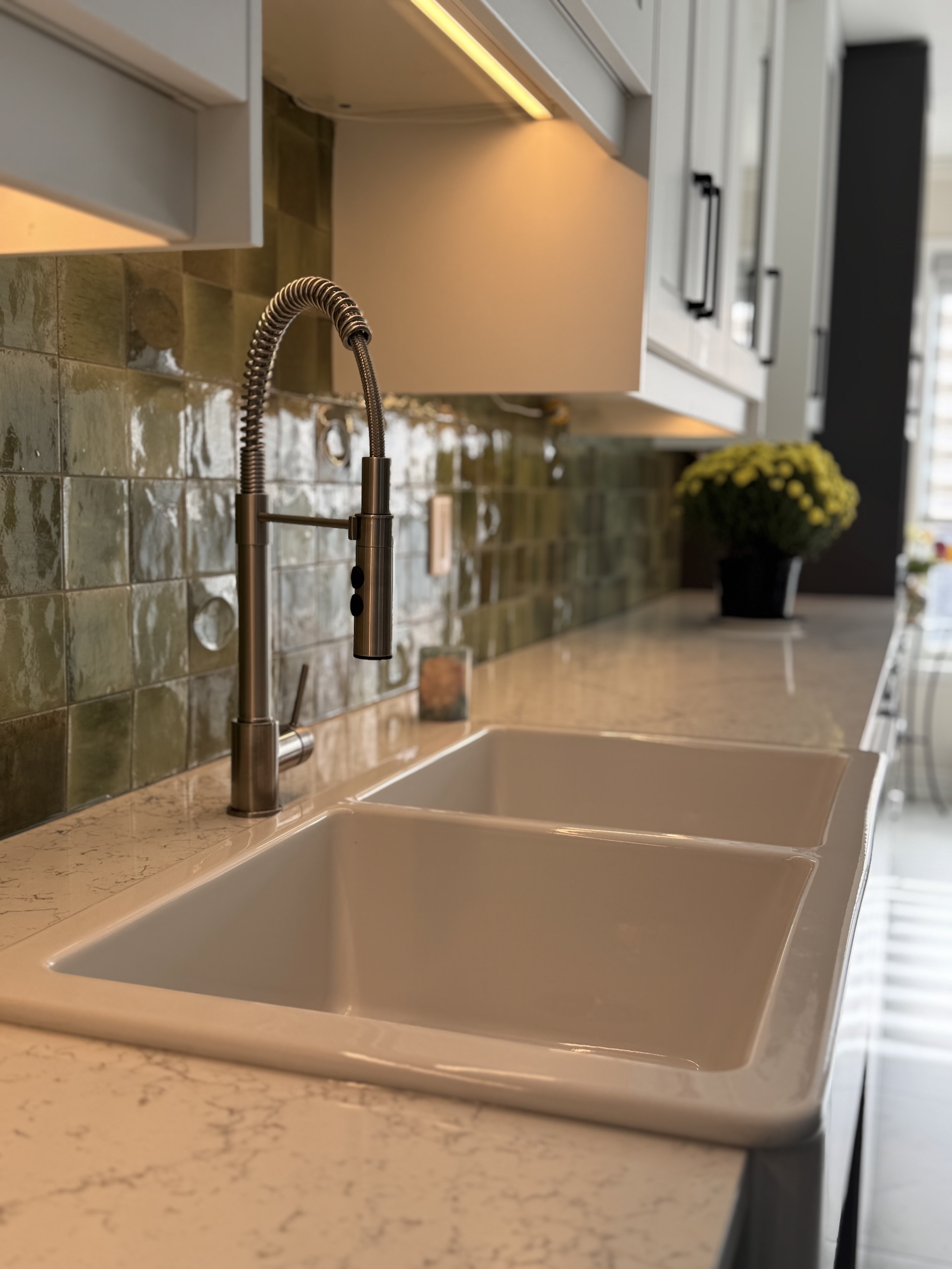 Close up of artisan green backsplash tile texture and kitchen faucet