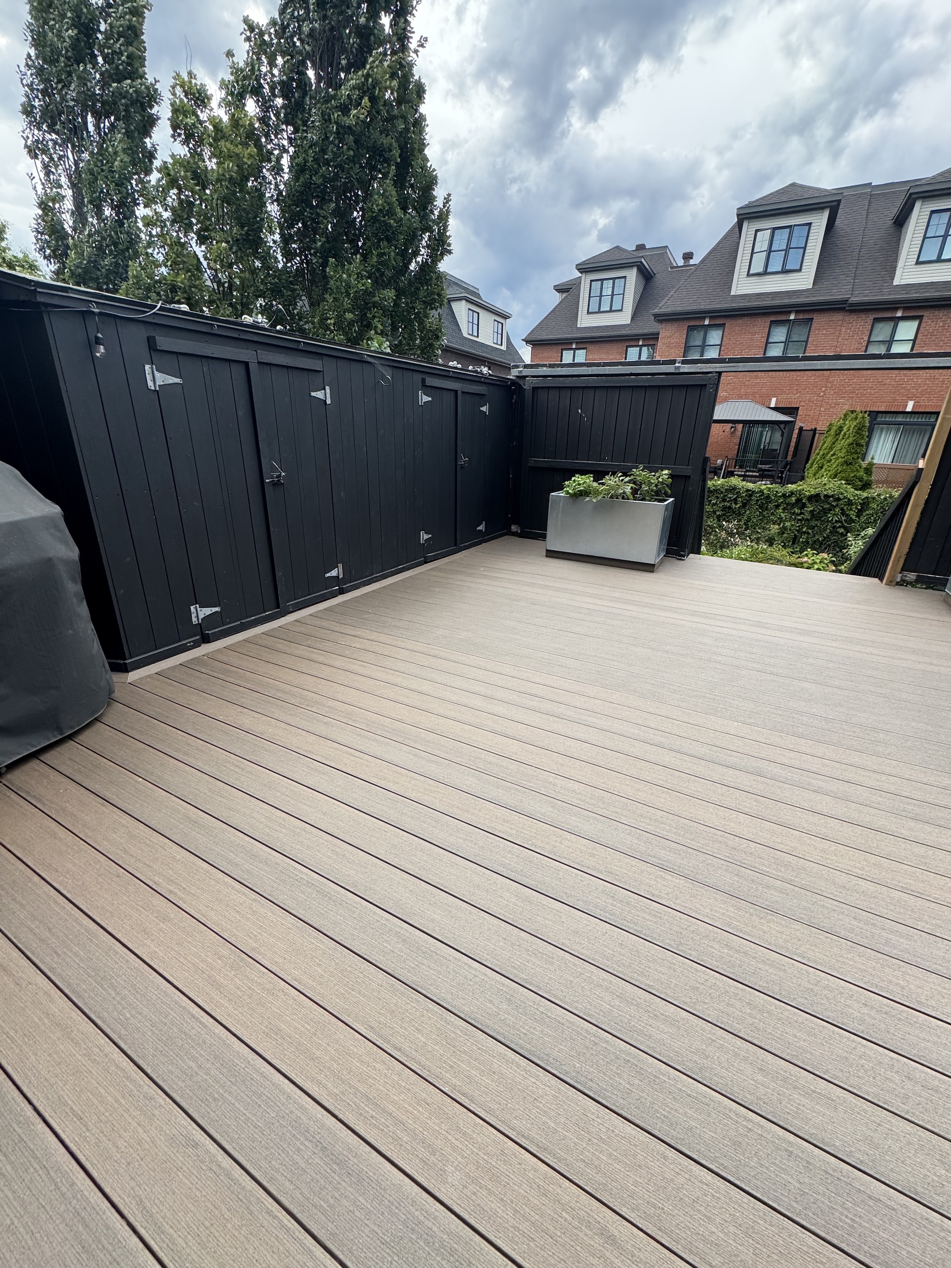 Spacious low-maintenance composite deck featuring custom black privacy fencing